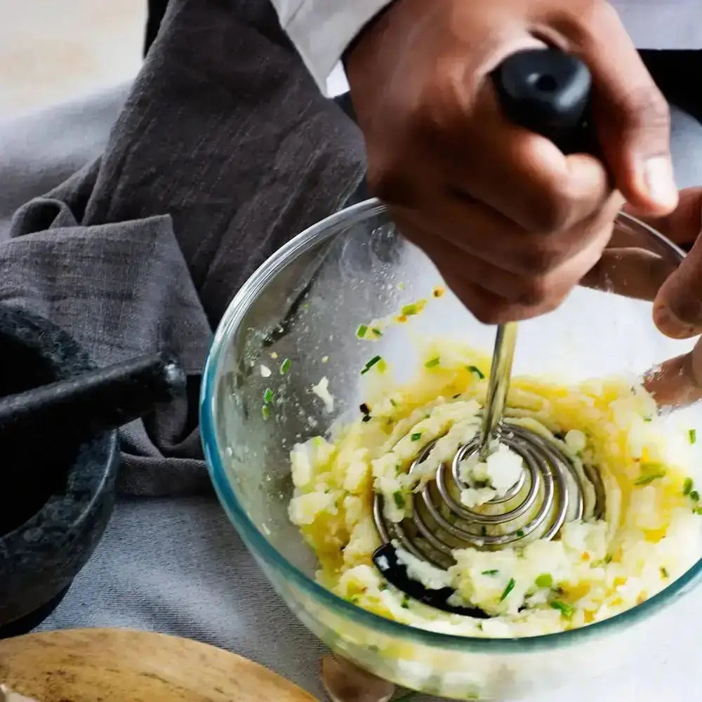 Dreamfarm Smood Masher in charcoal black mashing potatoes in glass bowl, Cookin Stores kitchenware