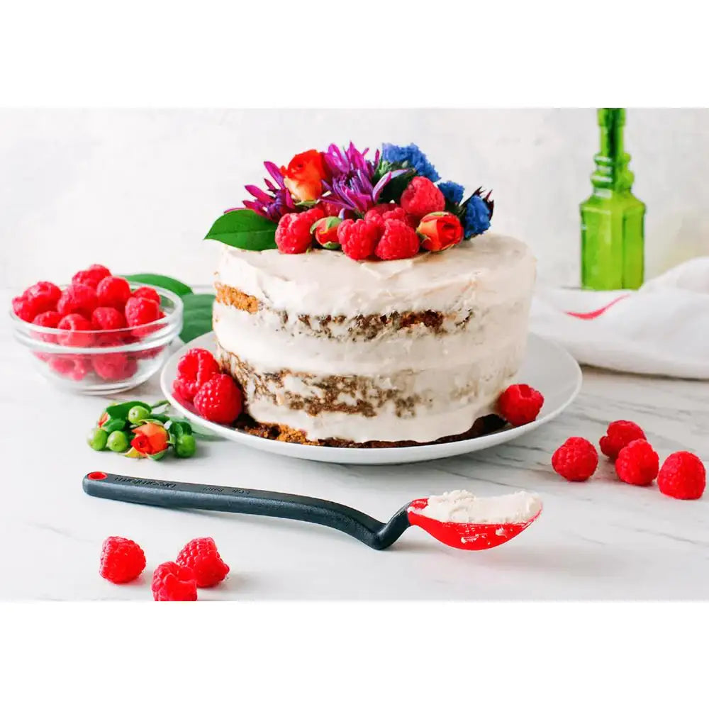Two-layer cake with white frosting and fresh berries on a white surface.