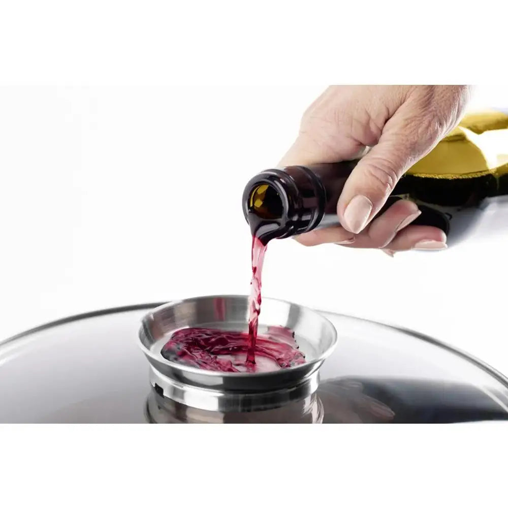 Hand pouring red wine from a bottle into a glass on a white background