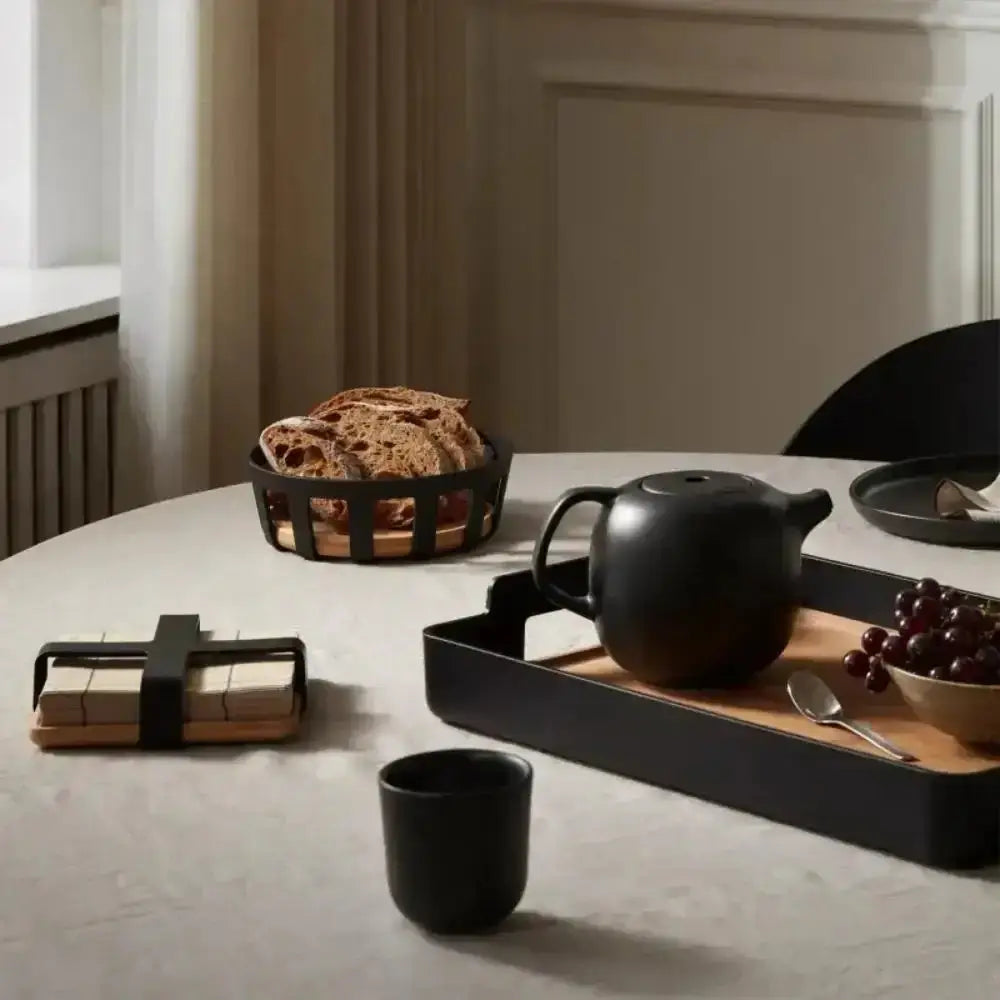 Eva Solo Nordic bamboo serving tray with black teapot, grapes, and bread on a kitchen table