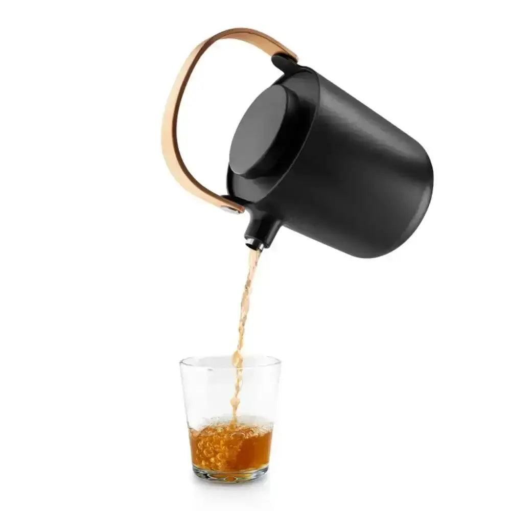 Black Eva Solo Nordic tea vacuum jug with wooden handle pouring tea into glass, Cookin Stores