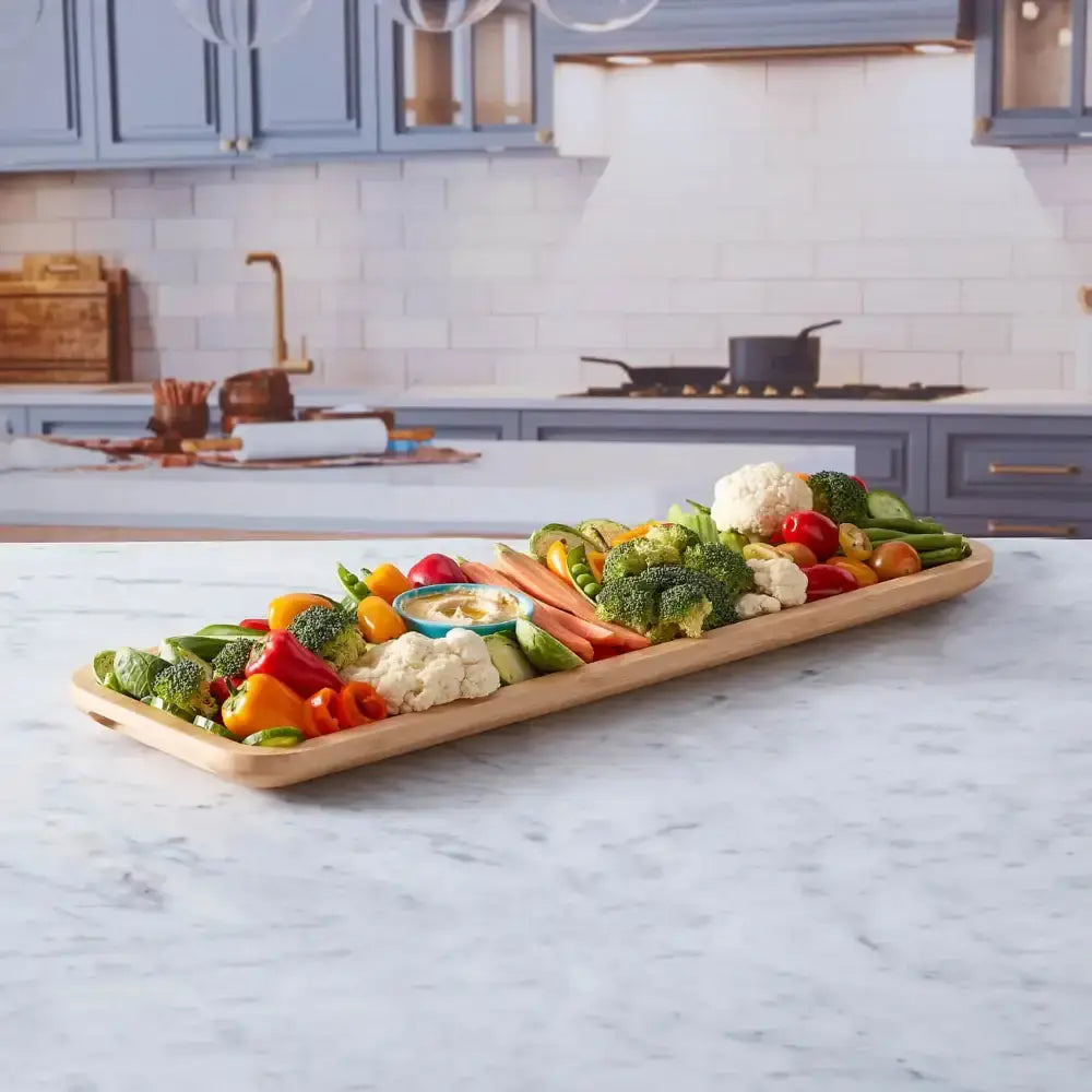 Assorted vegetables on a wooden tray in a kitchen setting