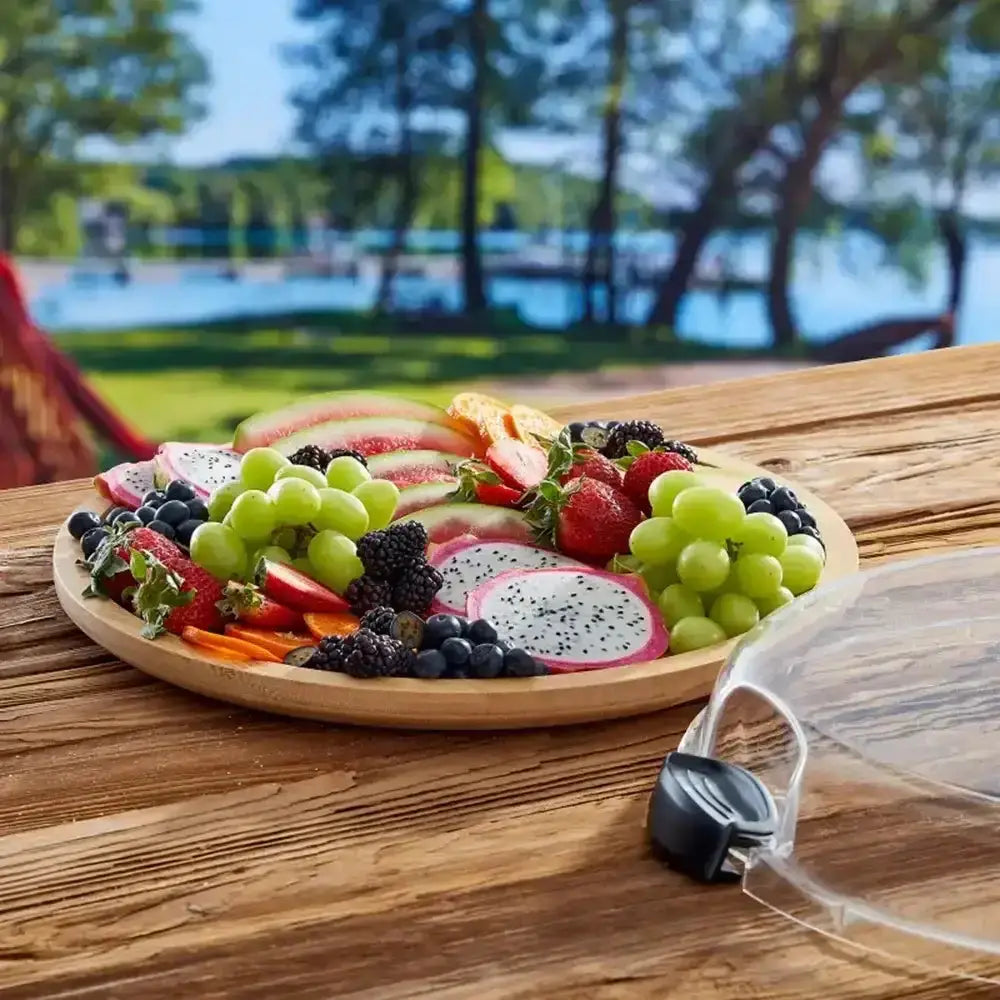 Fruit platter on a wooden table with a lakeside background