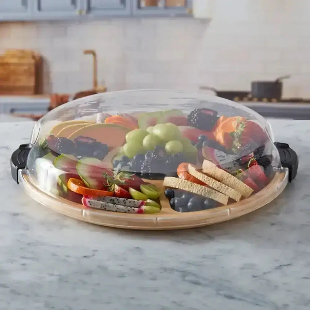 Farberware build-a-board bamboo lazy susan with clear plastic dome and black handles covering fruit and cheese tray