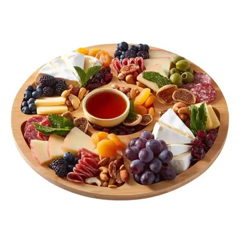 Farberware build-a-board round bamboo lazy susan cheese board with compartments holding cheeses meats fruits nuts and dip