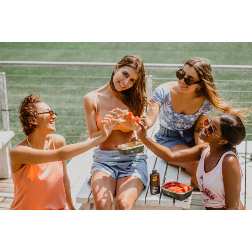 Four women sitting together outdoors, enjoying a sunny day.