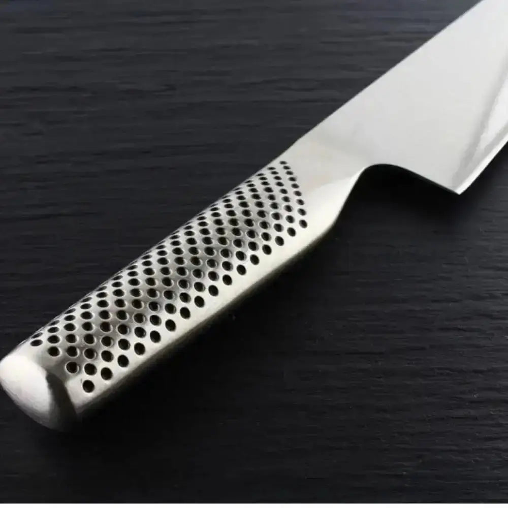 Stainless steel knife with perforated handle on a dark surface