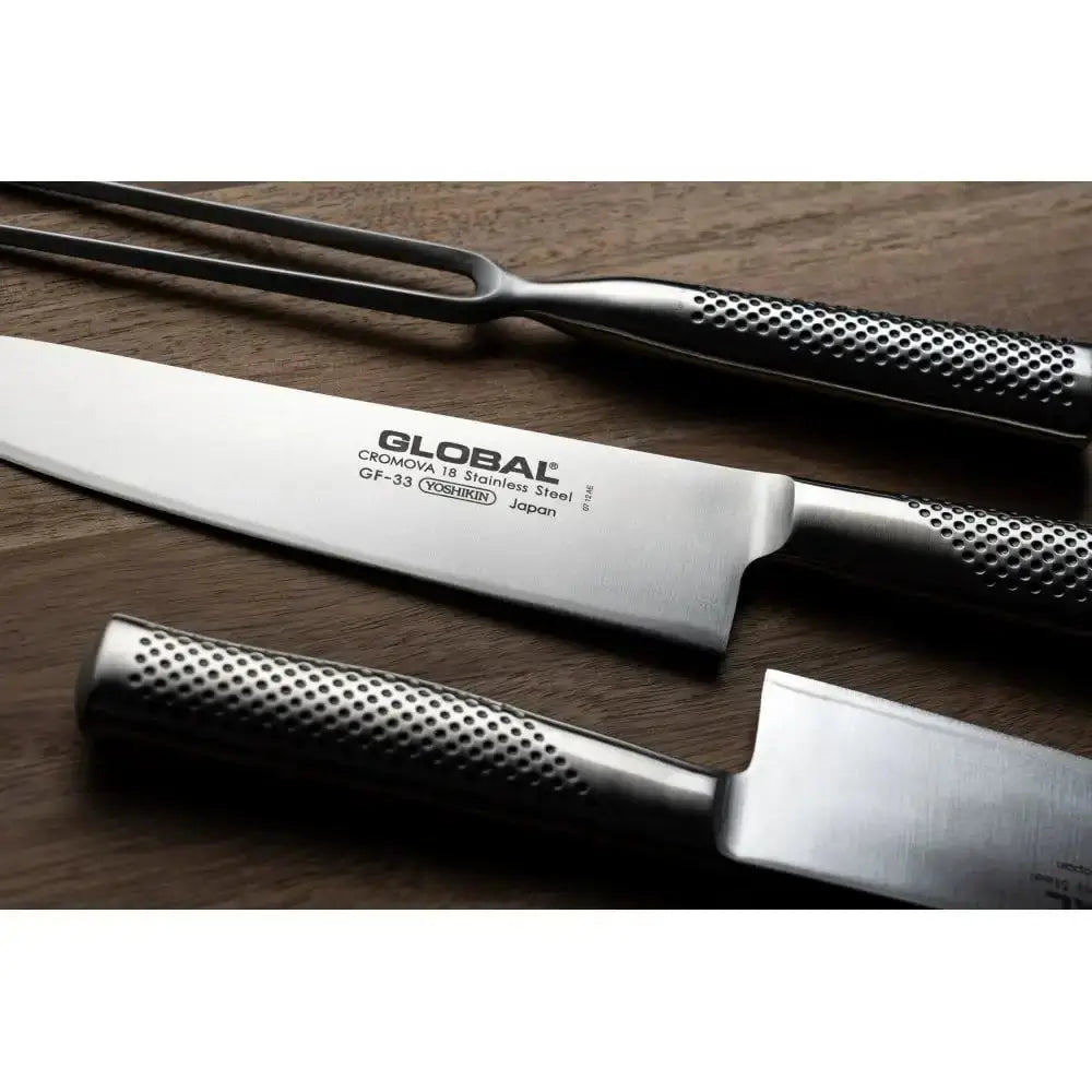 Set of knives and a fork on a wooden surface with 'GLOBAL' branding.