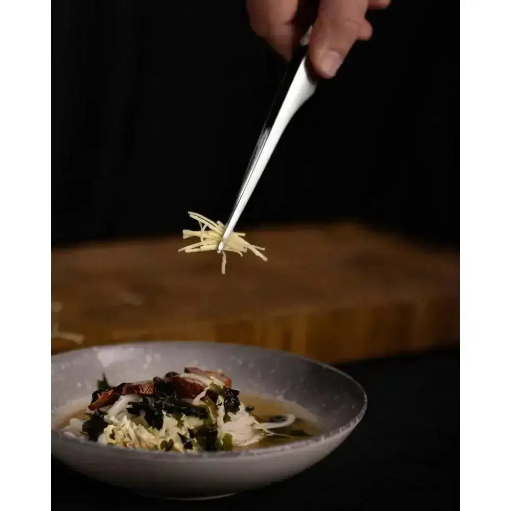 Noodles being lifted from a bowl with a dark background
