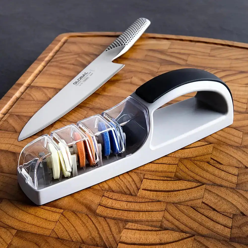 Knife sharpener with a knife on a wooden cutting board
