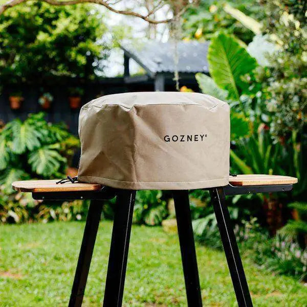 Gozney Arc XL pizza oven cover on stand in lush outdoor garden, kitchenware from Cookin Stores