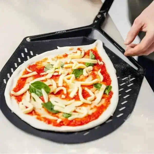 Homemade pizza with mozzarella and basil on a Gozney pizza peel at Cookin Stores kitchenware shop