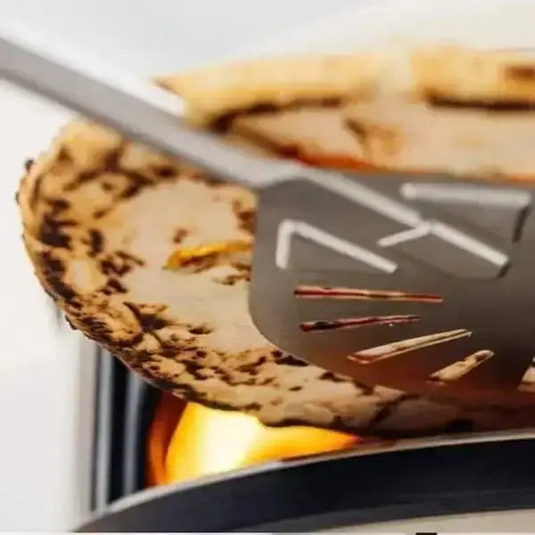 Gozney Balance Turning Peel flipping pizza over flame in a modern pizza oven, Cookin Stores kitchenware