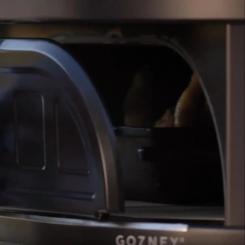 Person removing a Gozney oven door with a cloth