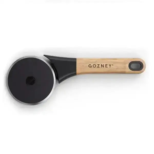 Gozney pizza cutter with black wheel and wooden handle on a white background