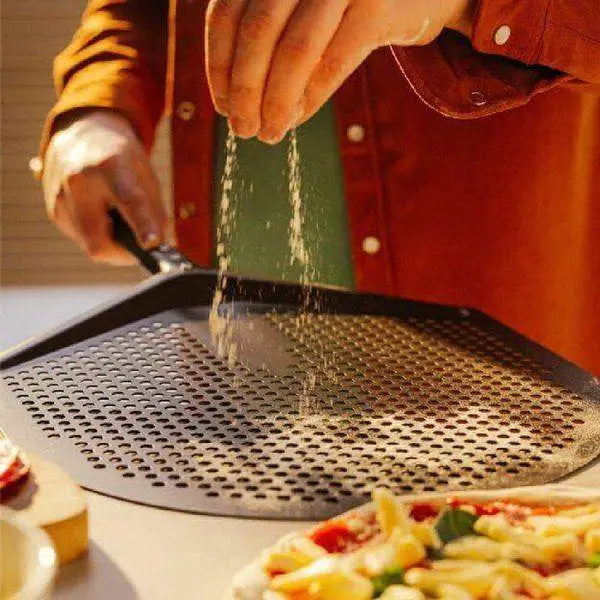 Hand dusting flour onto Gozney Pro Placement Peel pizza tool, pizza preparation, Cookin Stores