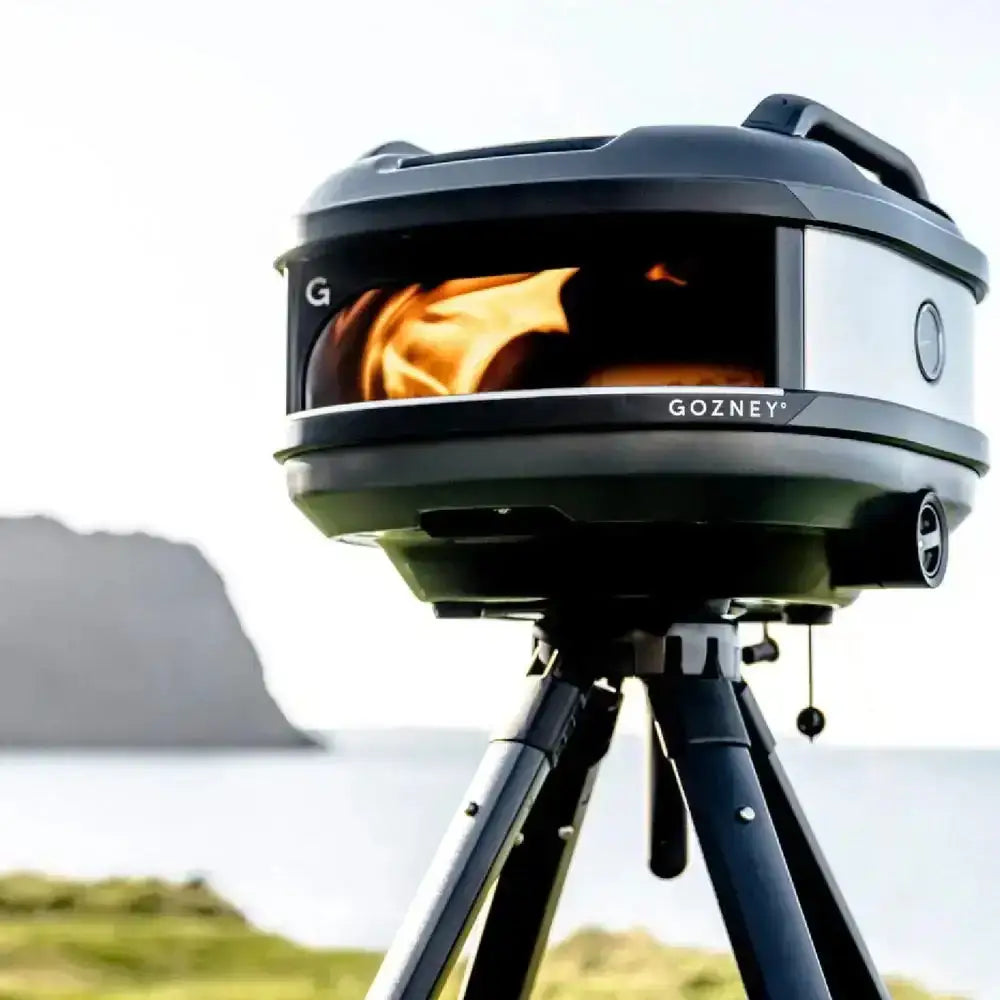 Gozney Tread portable outdoor pizza oven on tripod by Cookin Stores, in scenic landscape