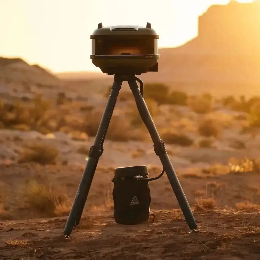 Gozney Tread Venture outdoor pizza oven on a tripod stand at sunset in a desert landscape