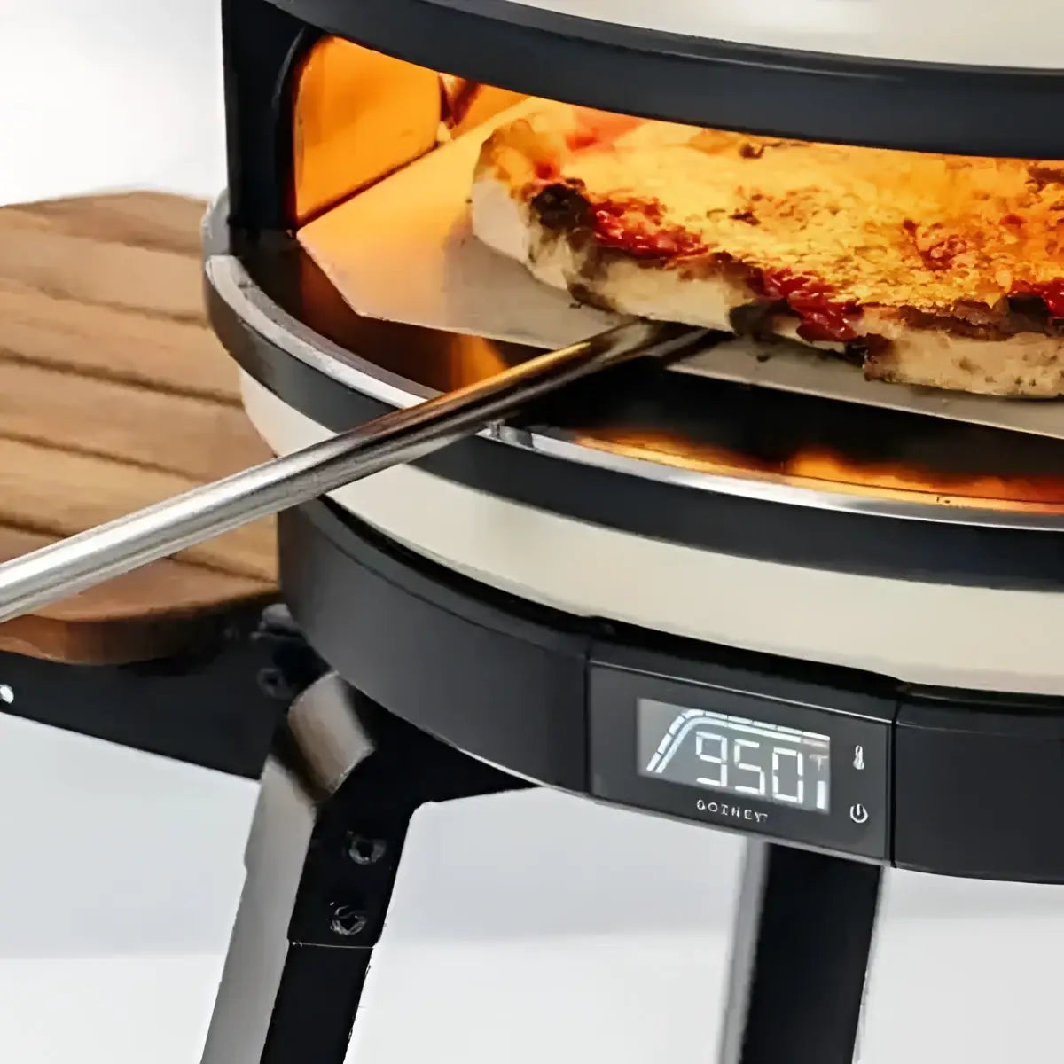 Gozney pizza oven with pizza on a turning peel at Cookin Stores kitchenware shop