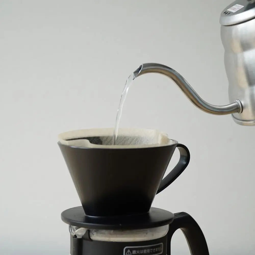 Coffee maker with a black filter basket on a white background