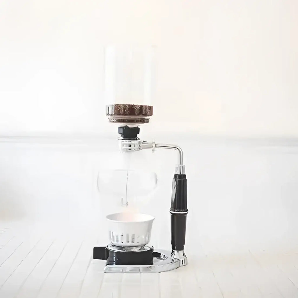 Manual coffee grinder with clear body and black handle on a white background