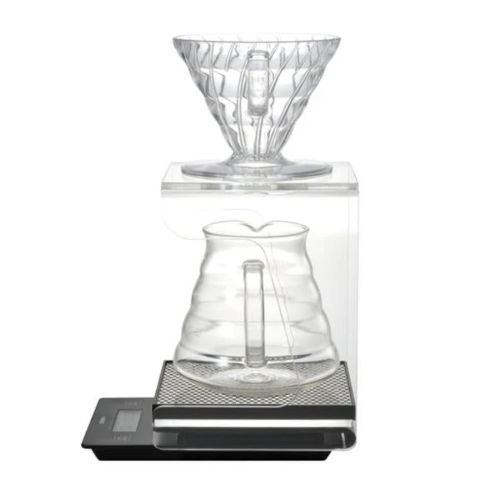 Clear glass coffee brewing device on a digital scale with a white background