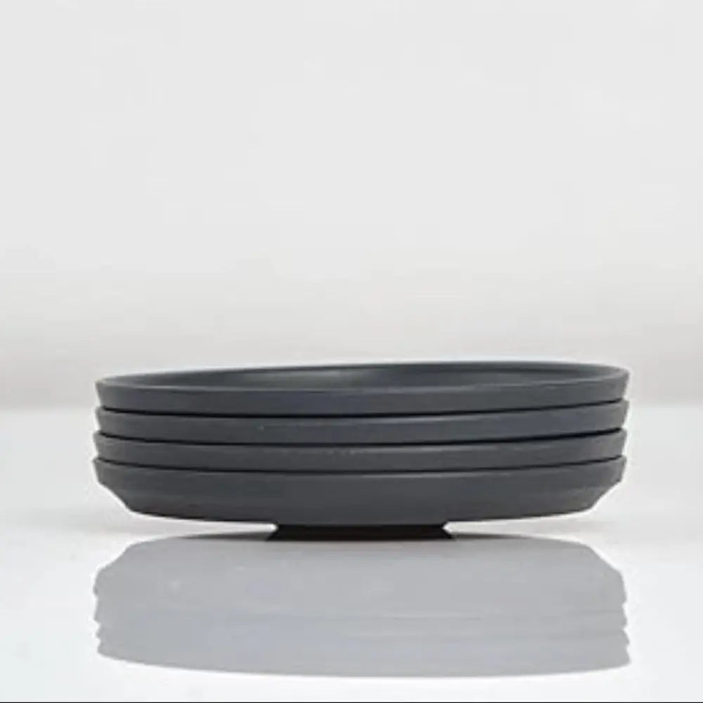 Stack of black ceramic saucers on a white background
