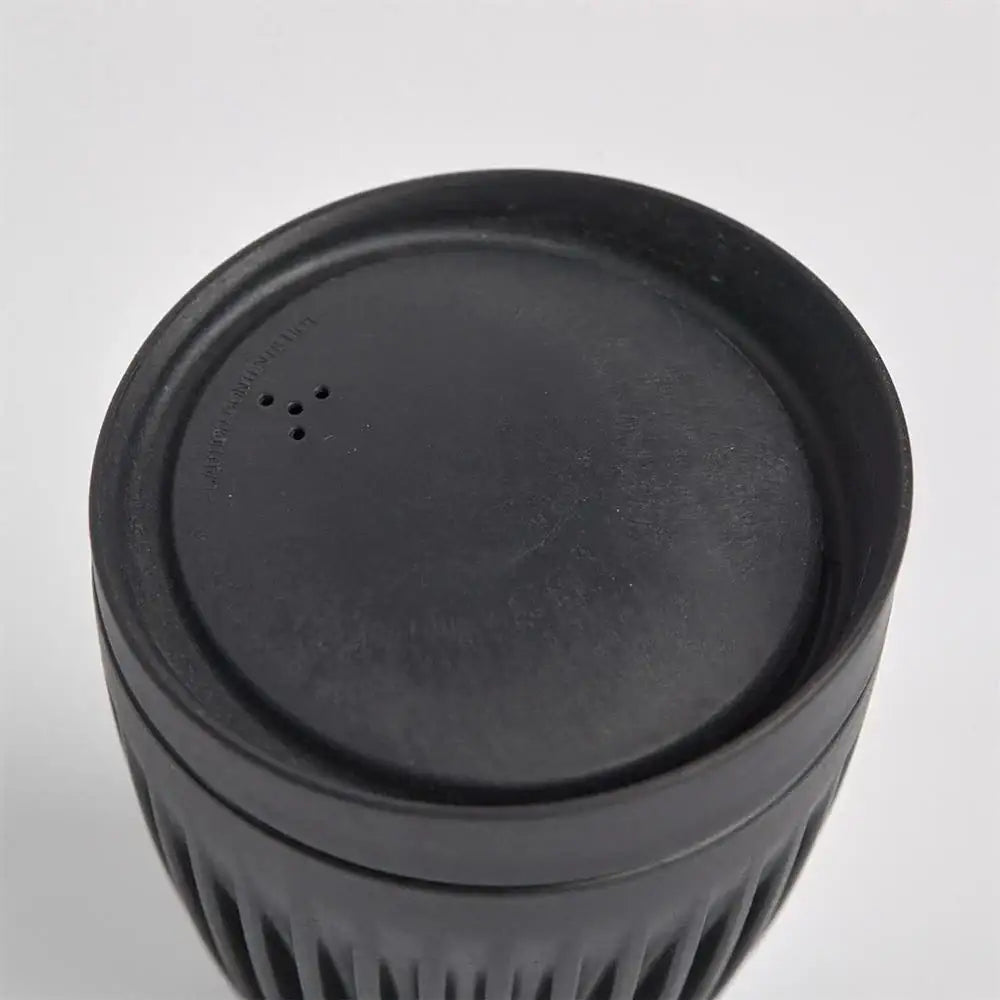 Black plastic container with lid on a white background