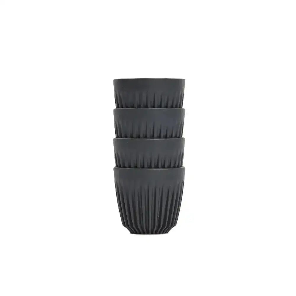 Set of four black ribbed cups stacked on a white background