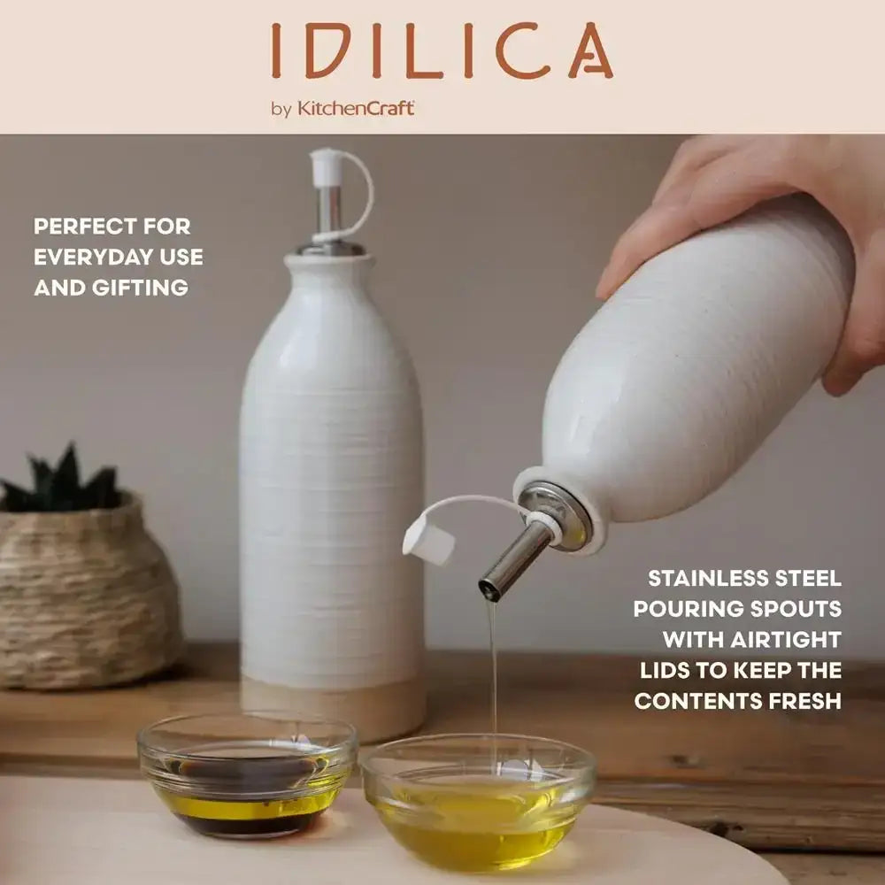 Set of two cream ceramic oil and vinegar bottles with stainless steel spouts and airtight lids.