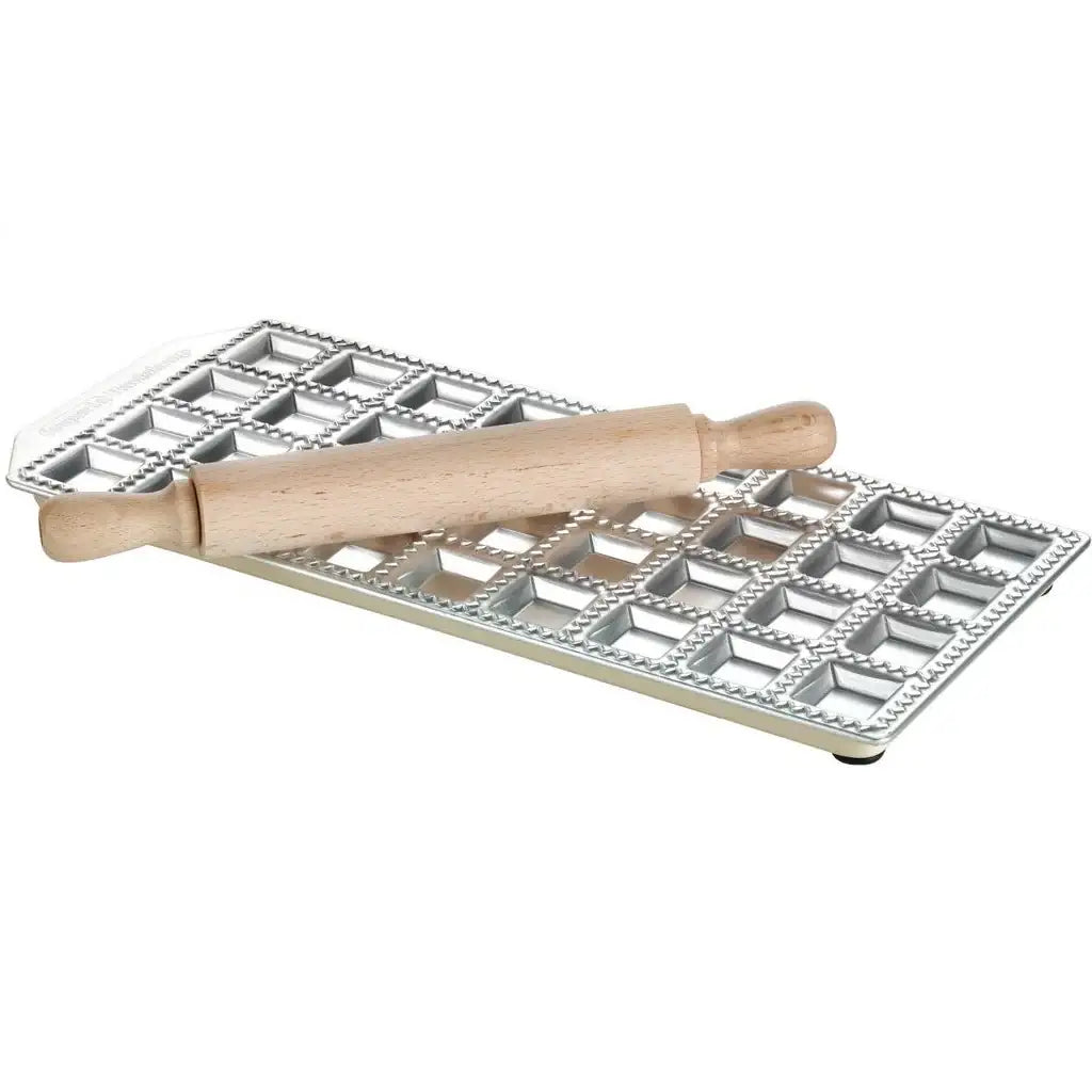 Metal baking tray with square compartments and a wooden rolling pin on a white background