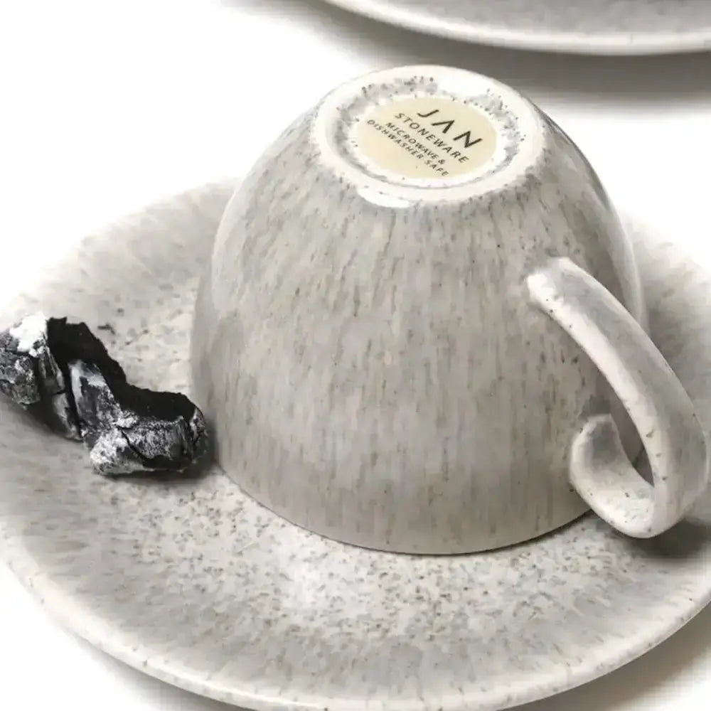 Ceramic cup and saucer with a textured finish on a white background