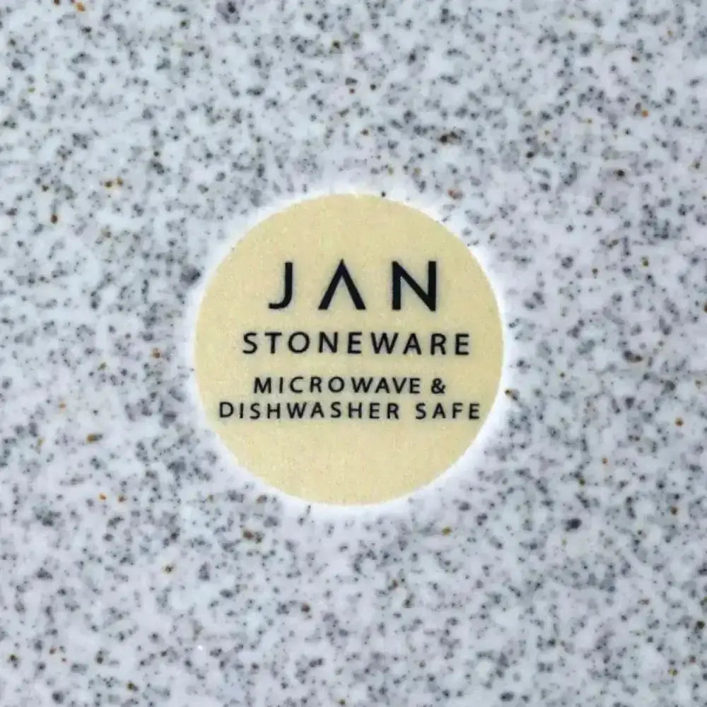 Round label on a speckled surface indicating 'JAN Stoneware' is microwave and dishwasher safe.