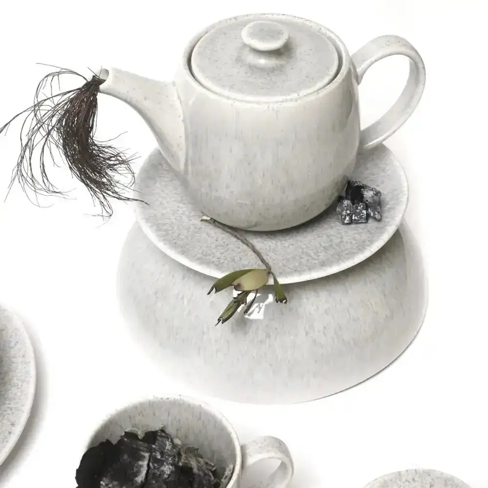Grey ceramic teapot and cup set on a white background