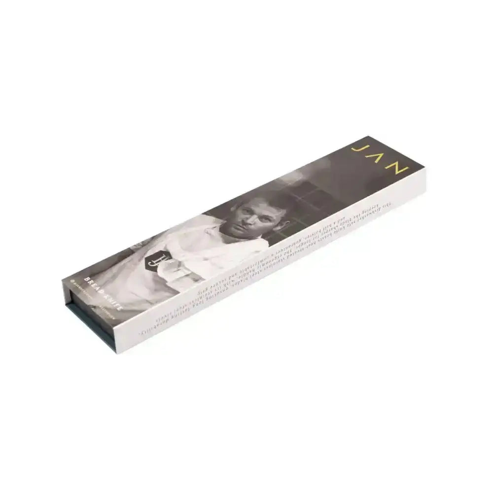 A sleek rectangular white magnetic box with a black and white photo and gold lettering for jan bread knife 20cm