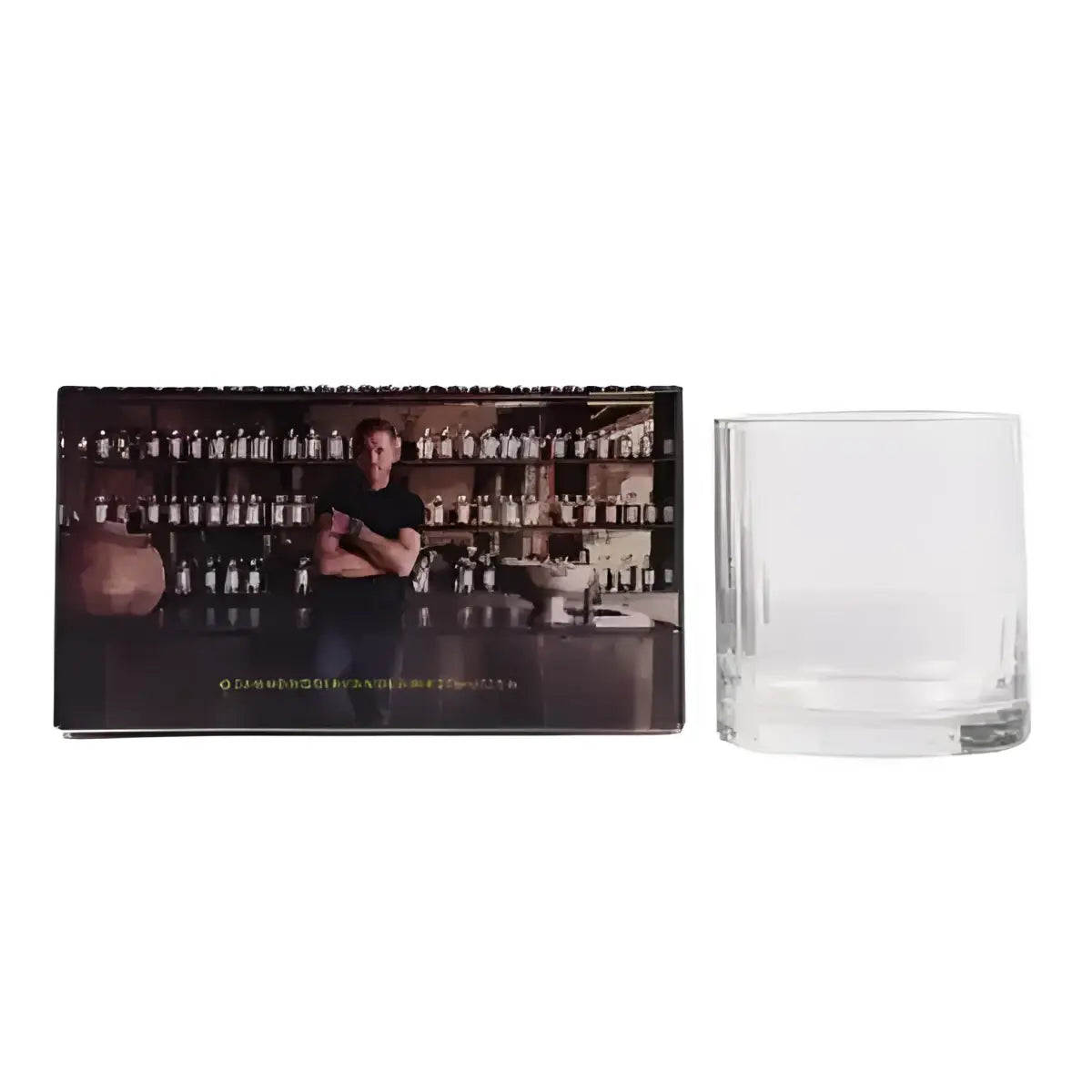 Clear glass tumbler next to a branded box with a person in a bar setting.