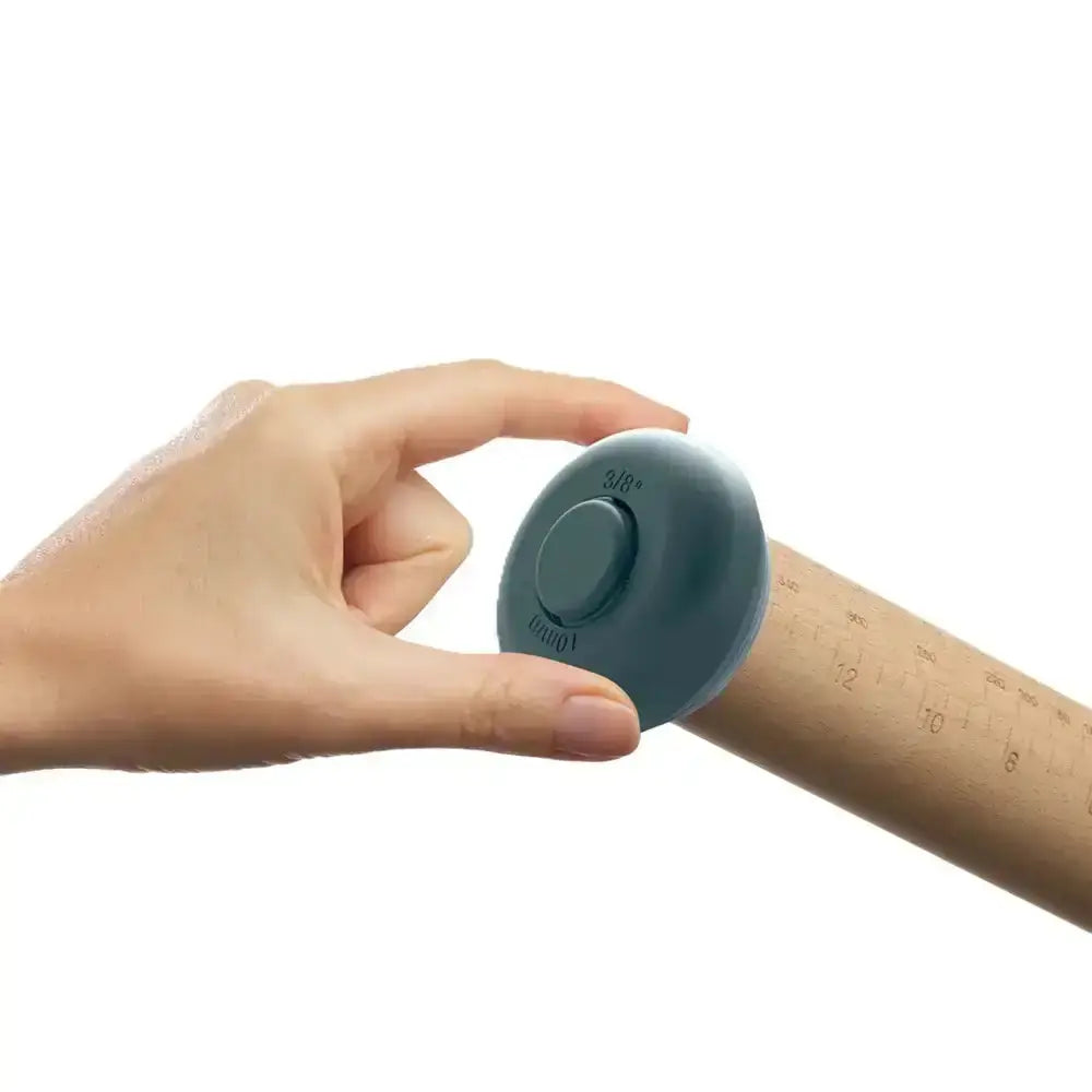 Hand holding a small blue device against a white background