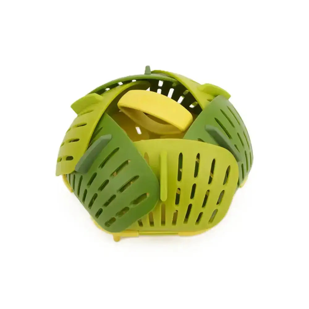 Green and yellow plastic steamer basket on a white background