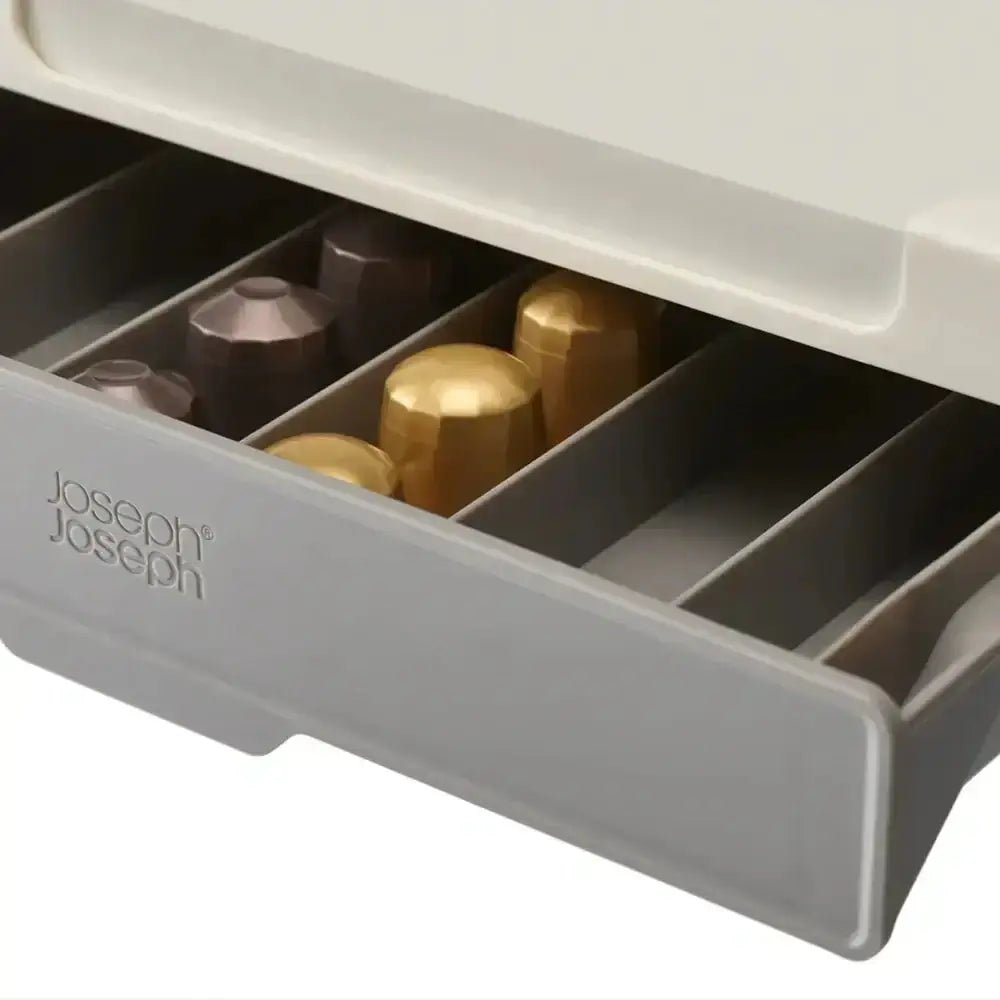 Gray Joseph Joseph drawer organizer with gold and bronze containers on a white background