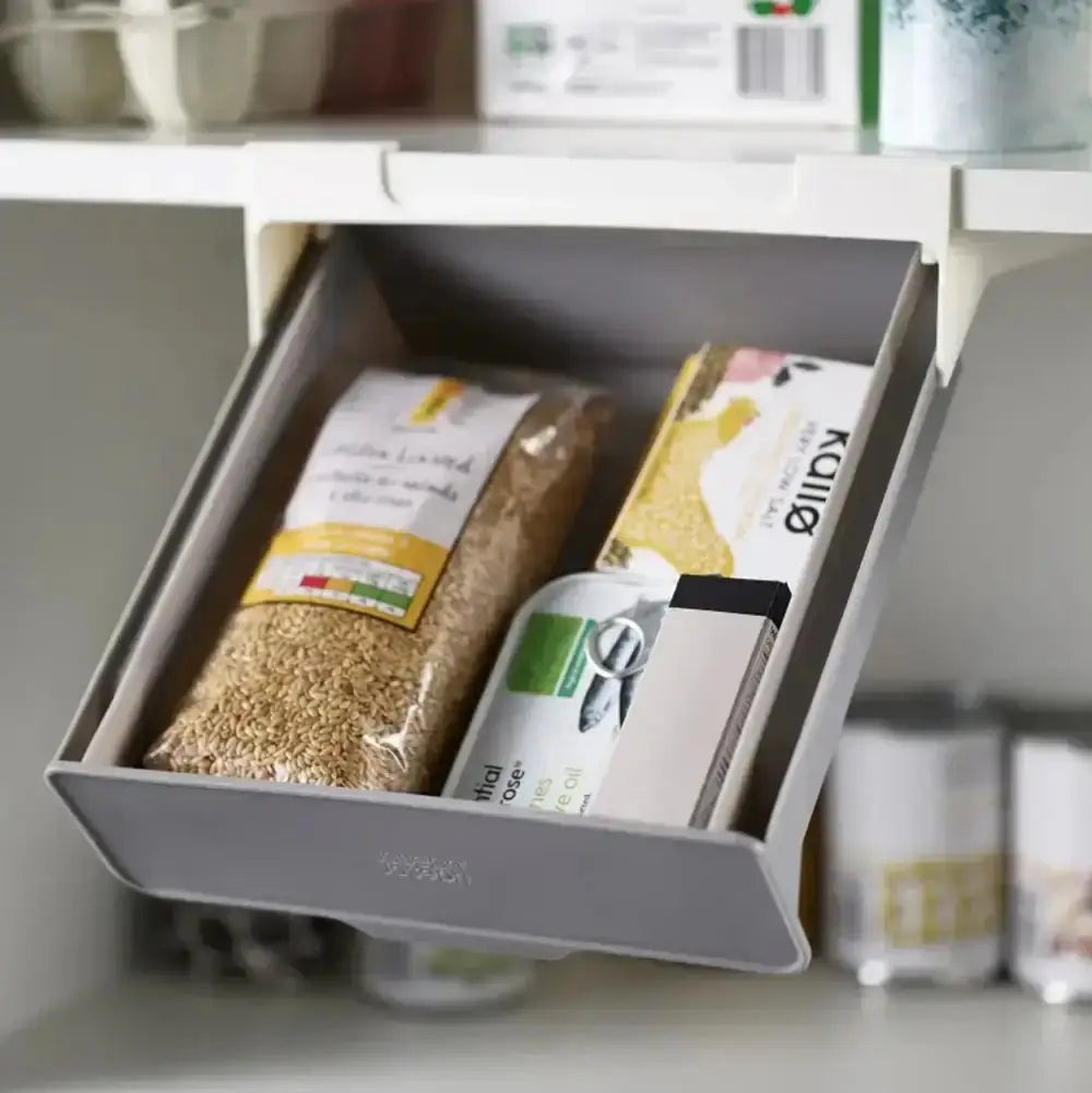 Kitchen cabinet with a pull-out drawer containing food packages.