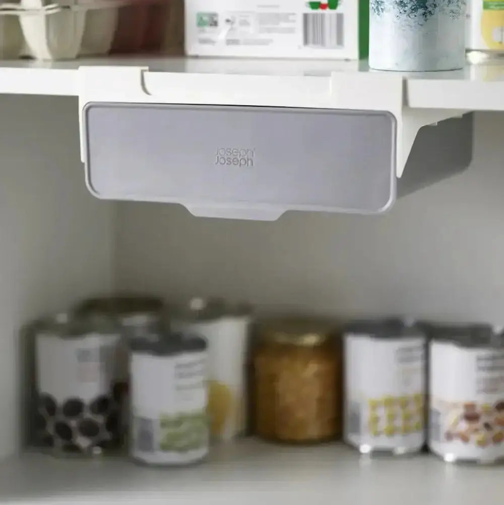 Under-shelf storage organizer with 'Joseph Joseph' branding in a kitchen setting.
