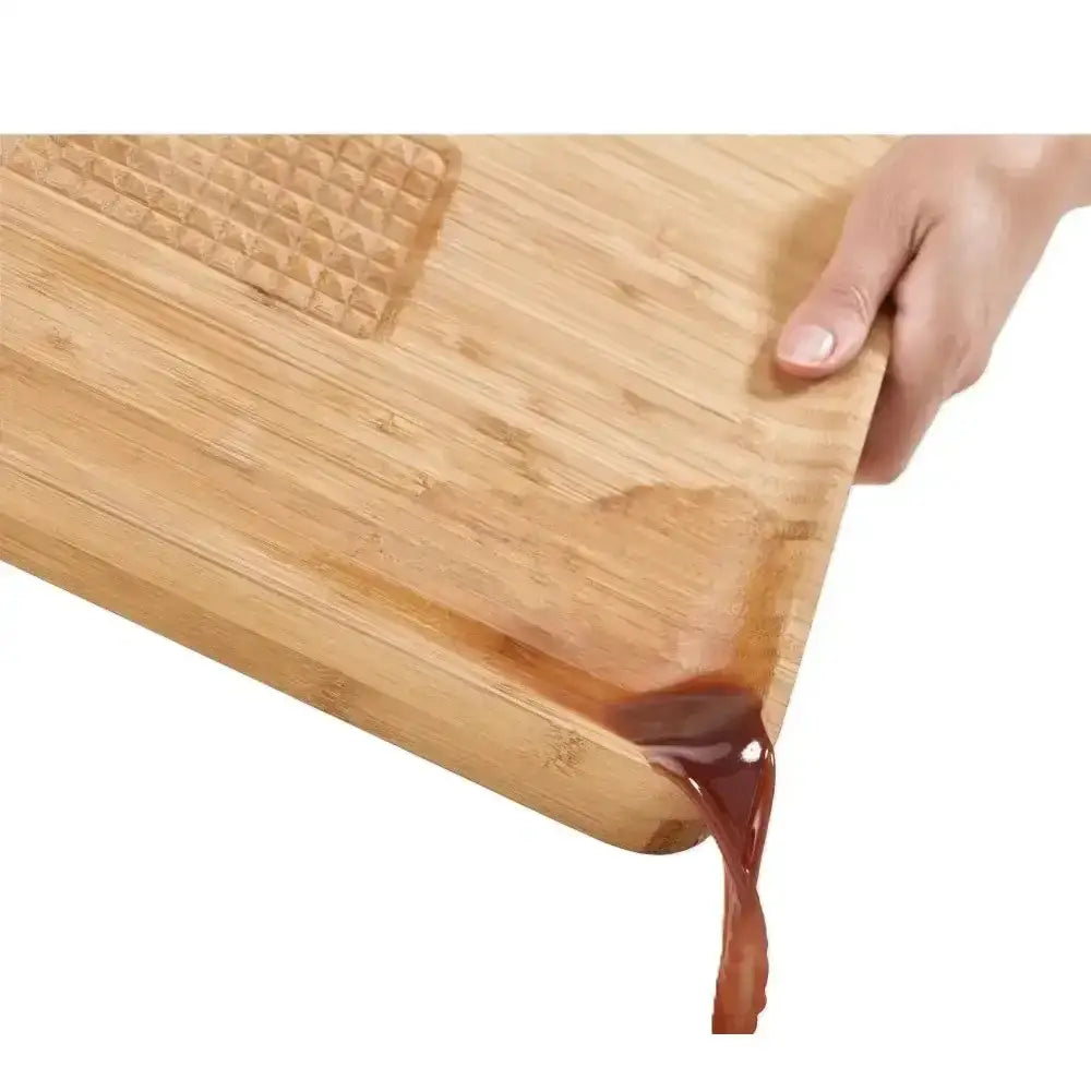 Wooden cutting board with a hand holding it, showing a clear silicone strip on the edge.