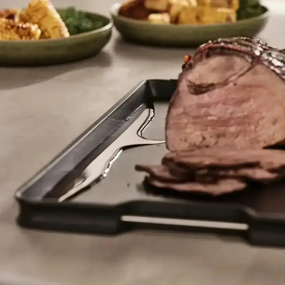 Sliced roast on a cutting board with blurred background of food