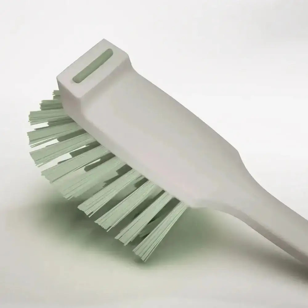 Green brush with a white handle on a light gray background