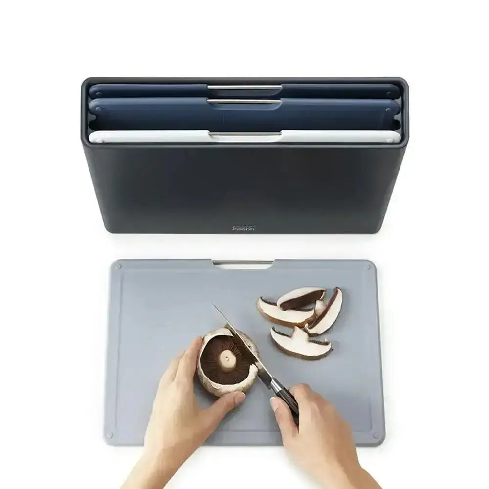 Person cutting mushrooms on a gray cutting board with a knife, next to a blue kitchen organizer.