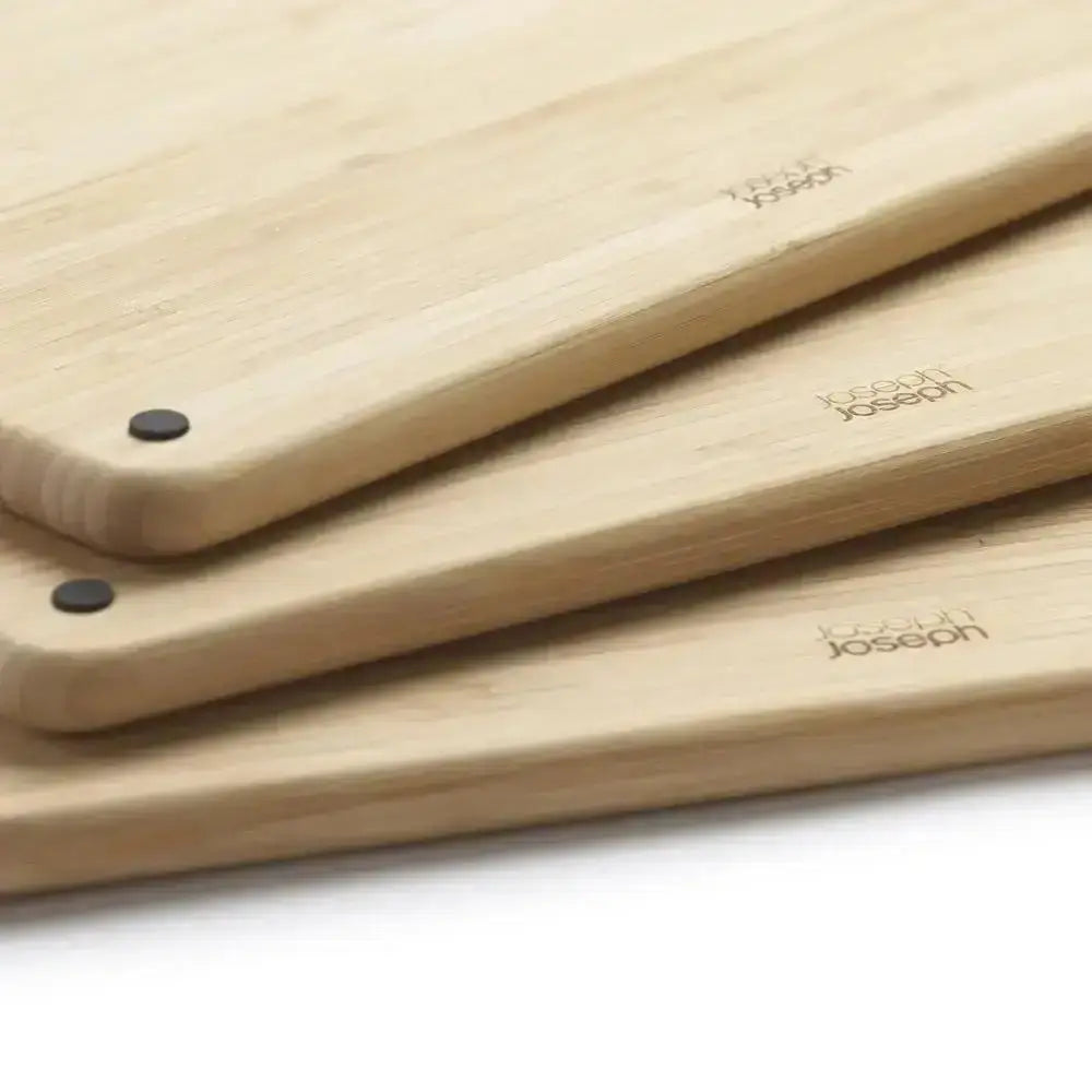 Three wooden cutting boards with 'Joseph Joseph' branding on a white surface