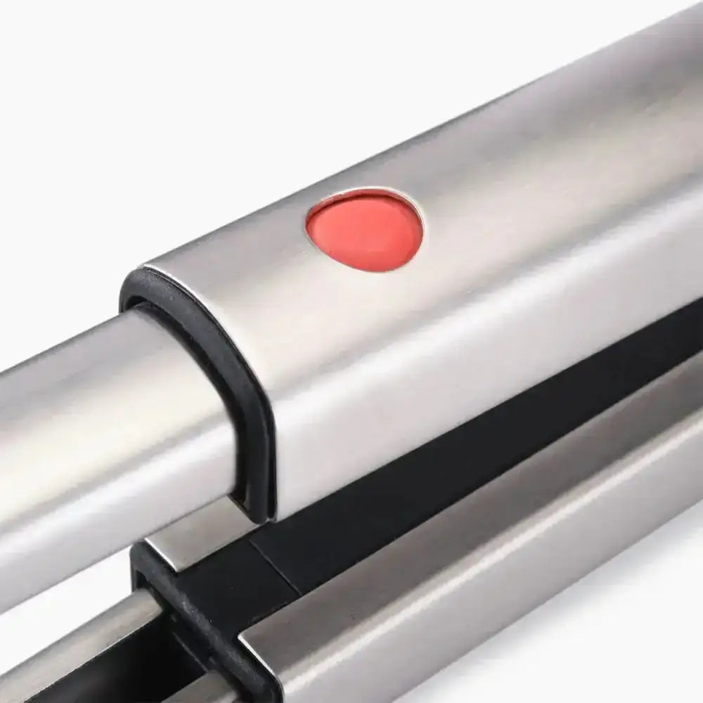 Close-up of a metallic object with a red button and black strap on a white background