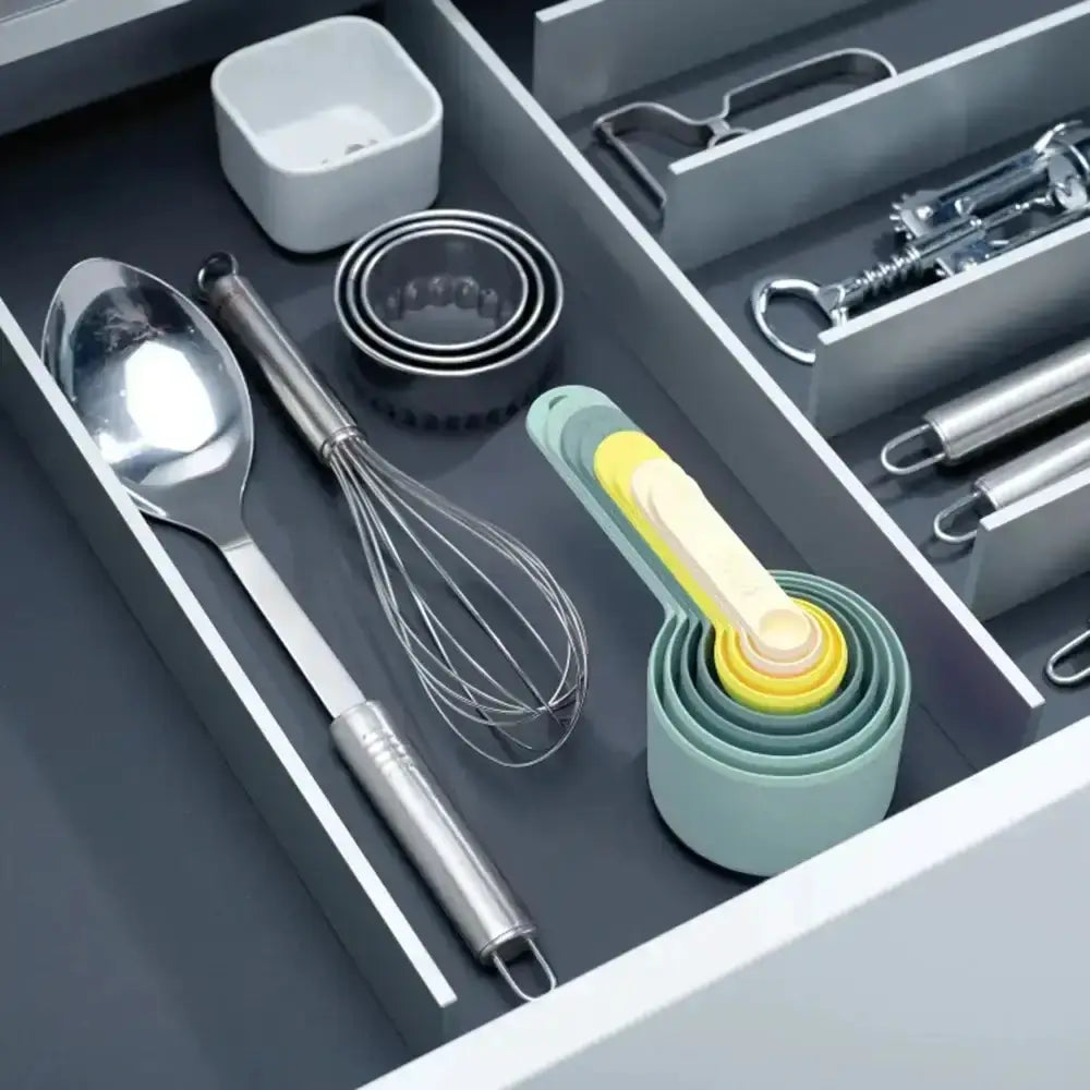 Open kitchen drawer with utensils and measuring cups