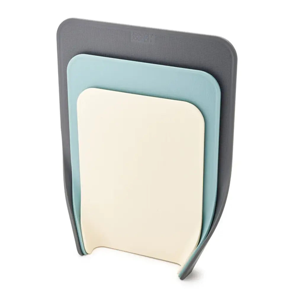 Set of three cutting boards in gray, blue, and beige on a white background