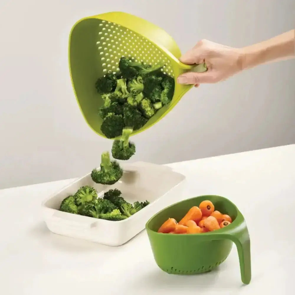Green colander being used to transfer broccoli into a white container on a gray background